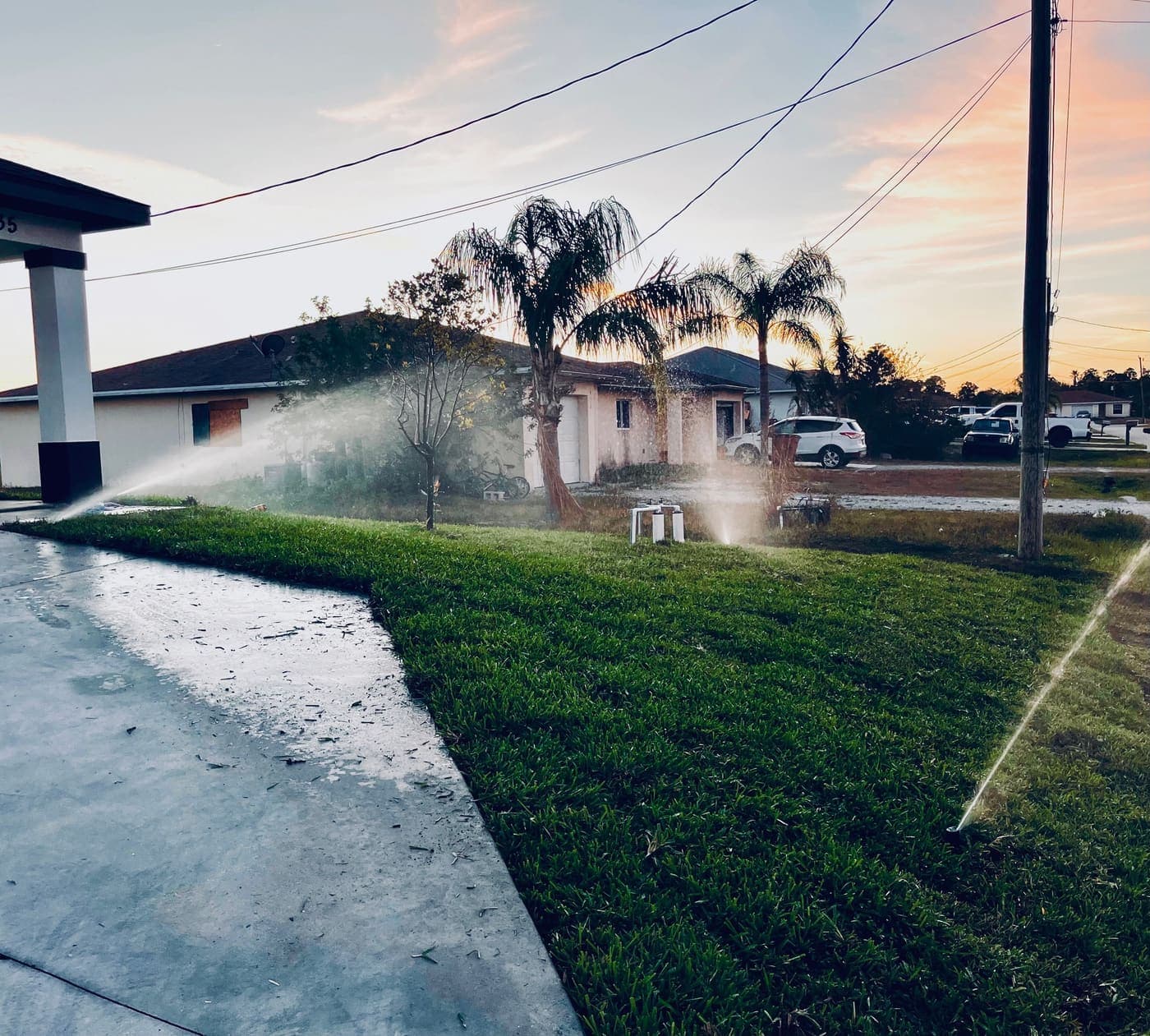Sprinklers running at dusk on a finished lawn